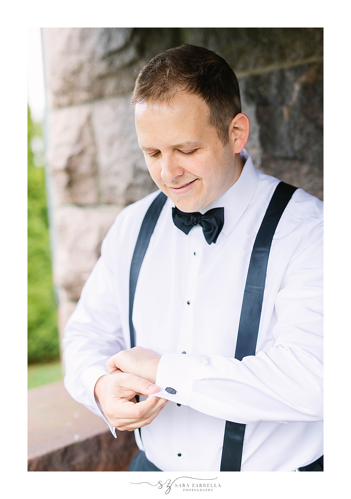 groom adjusts cufflinks before RI wedding