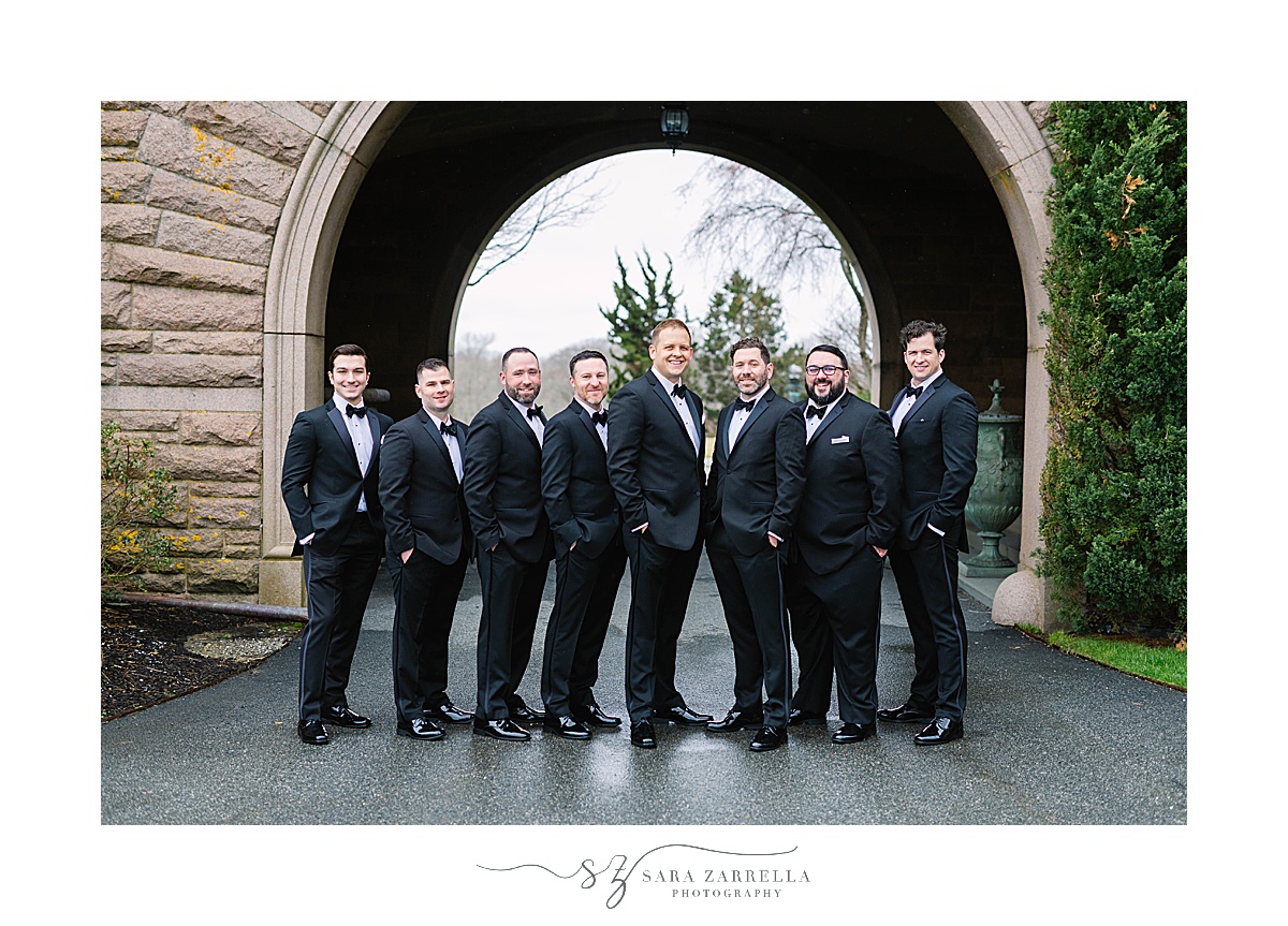 groom and groomsmen in classic tuxes pose outside OceanCliff Hotel