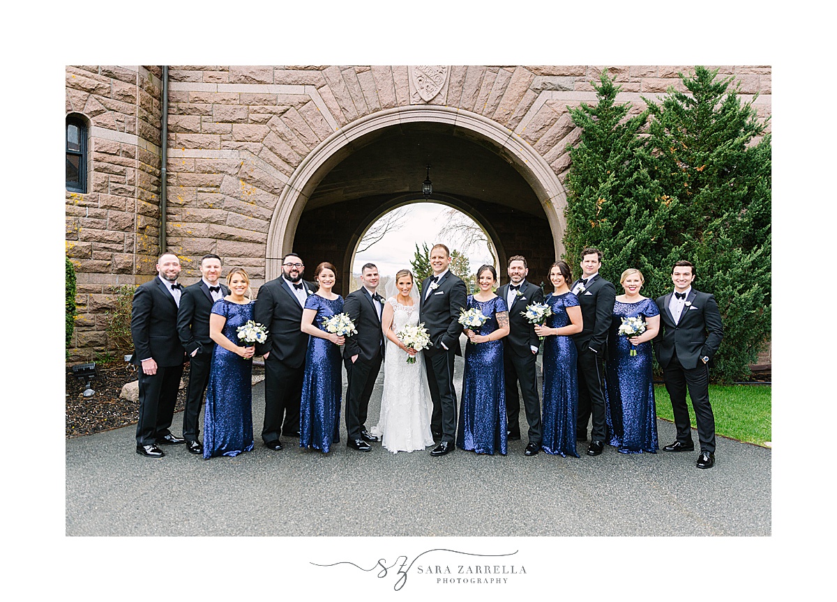bride and groom pose with bridal party in black and blue