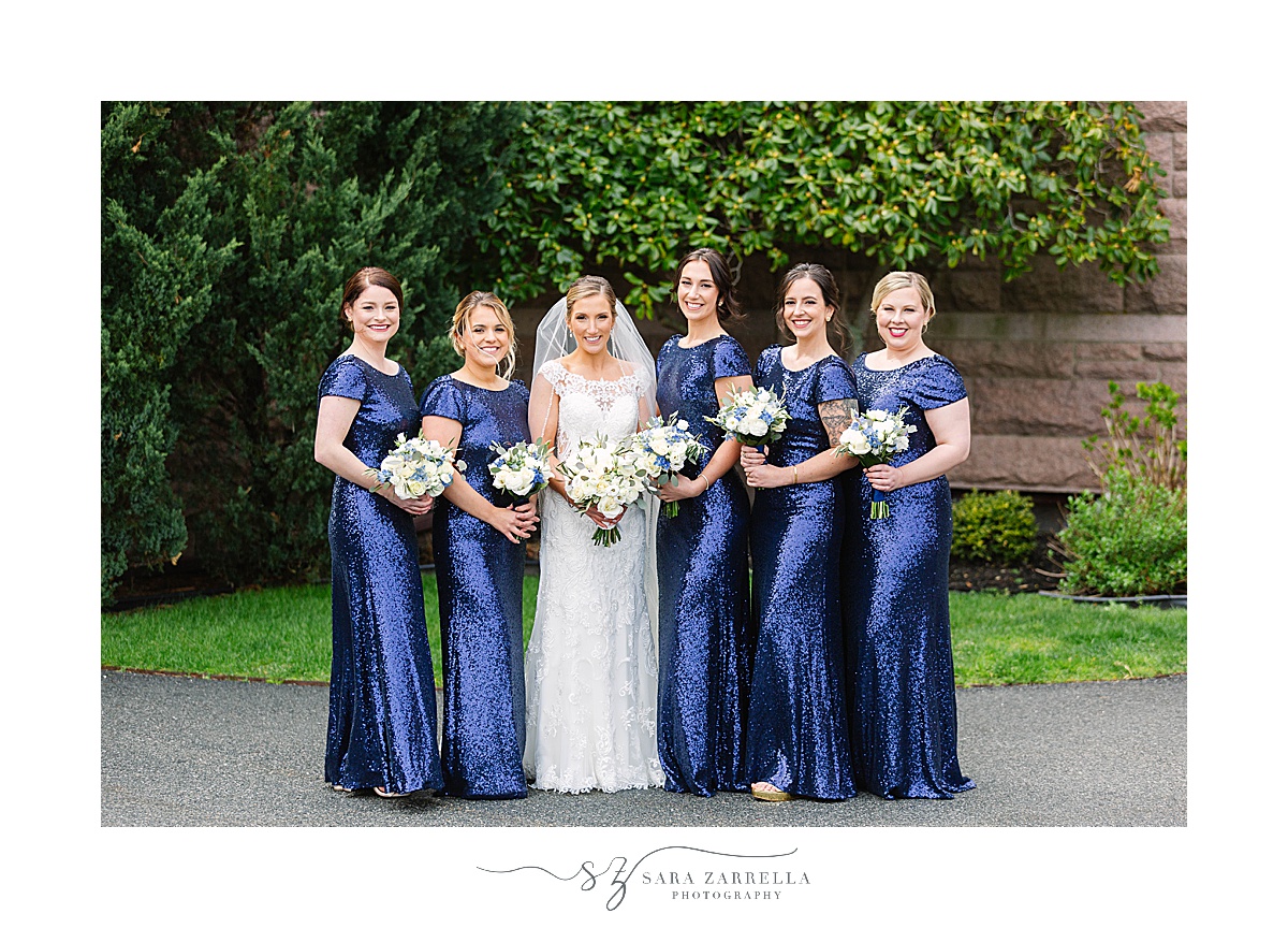 bride poses with bridesmaids in navy gowns