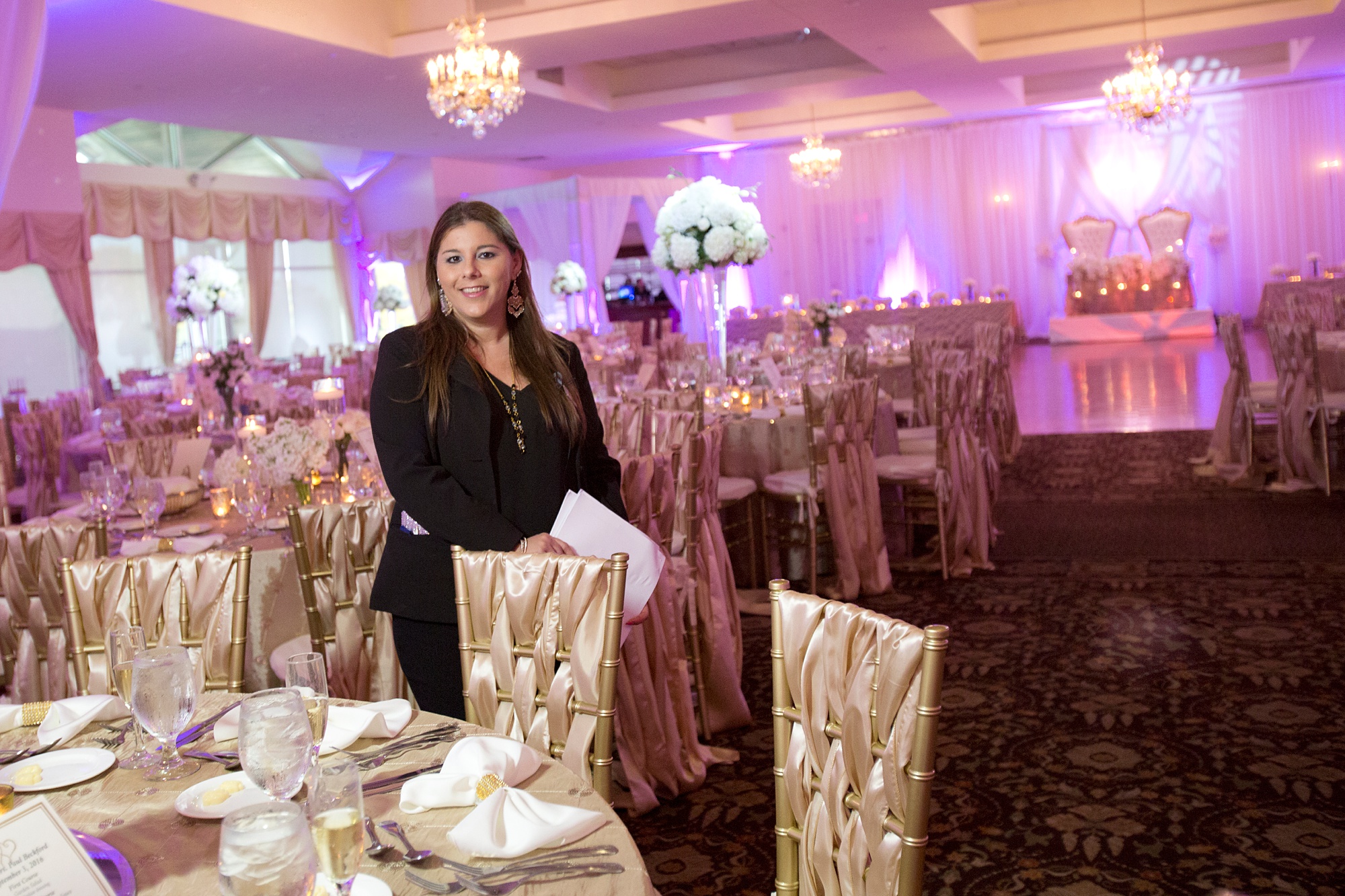 wedding planner poses in ballroom at Kirkbre Country Club during Rhode Island wedding day