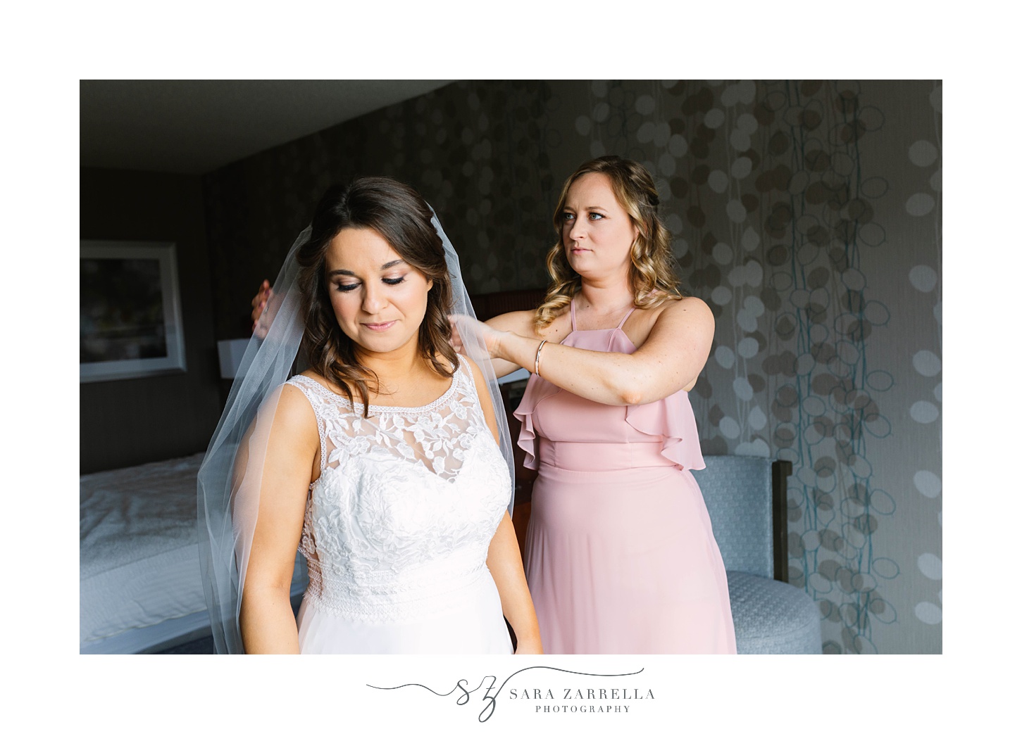 bridesmaid adjusts veil for bride before Lincoln RI wedding