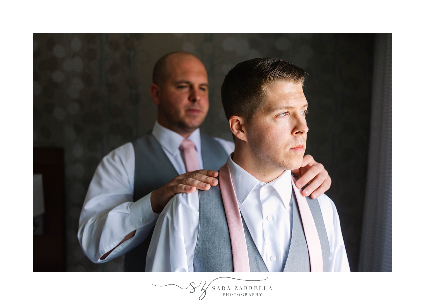 groomsman adjusts tie for groom during RI wedding