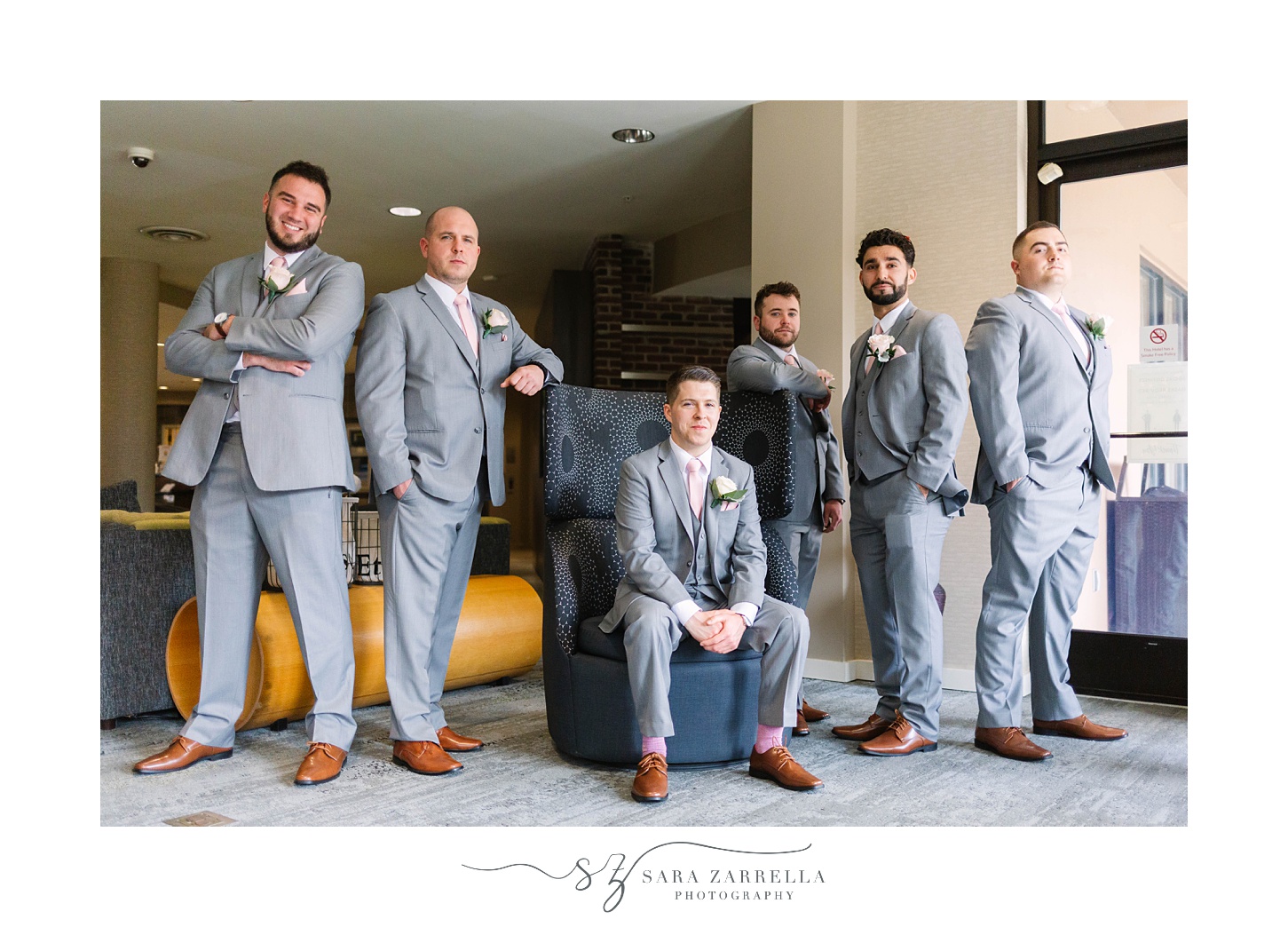 groom and groomsmen pose inside Rhode Island hotel