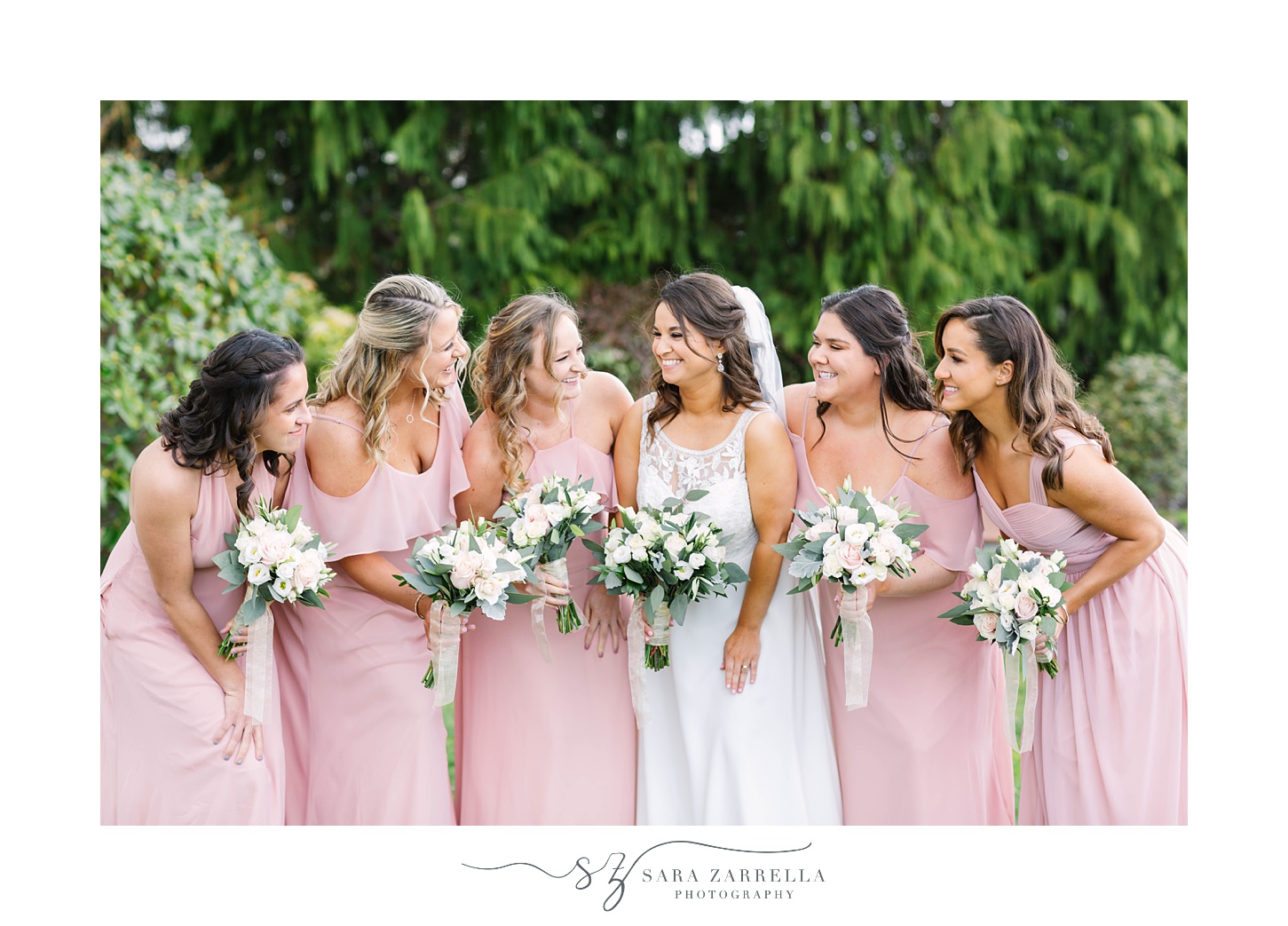bride laughs with bridesmaids in pale pink gowns