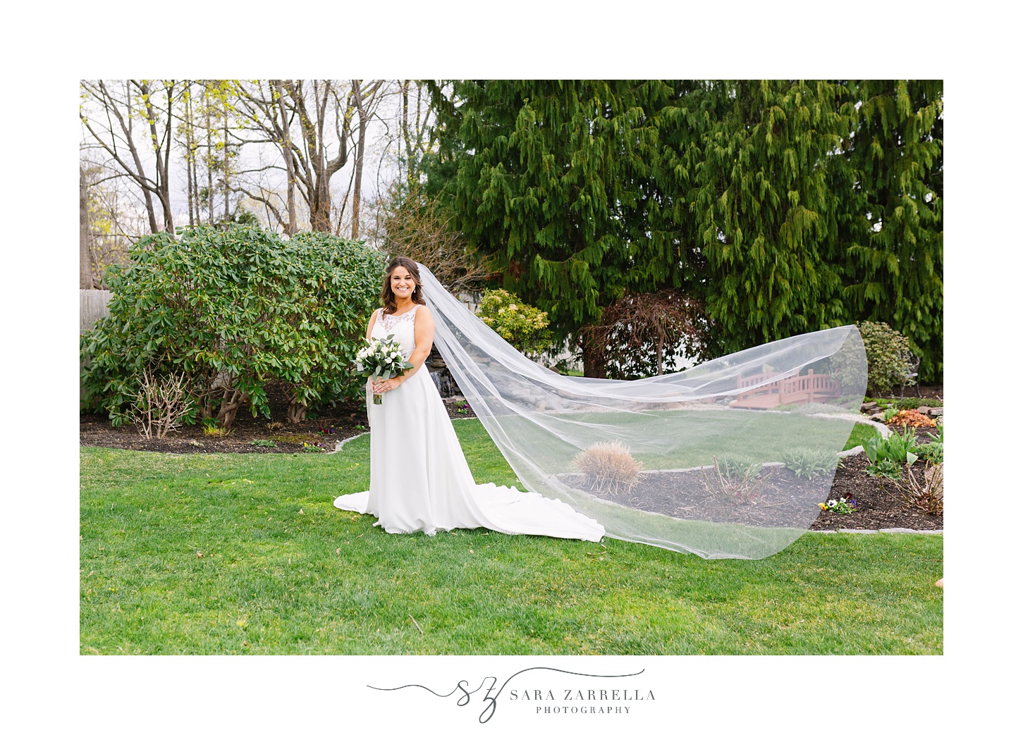 bride holds bouquet of flowers with veil floating behind her