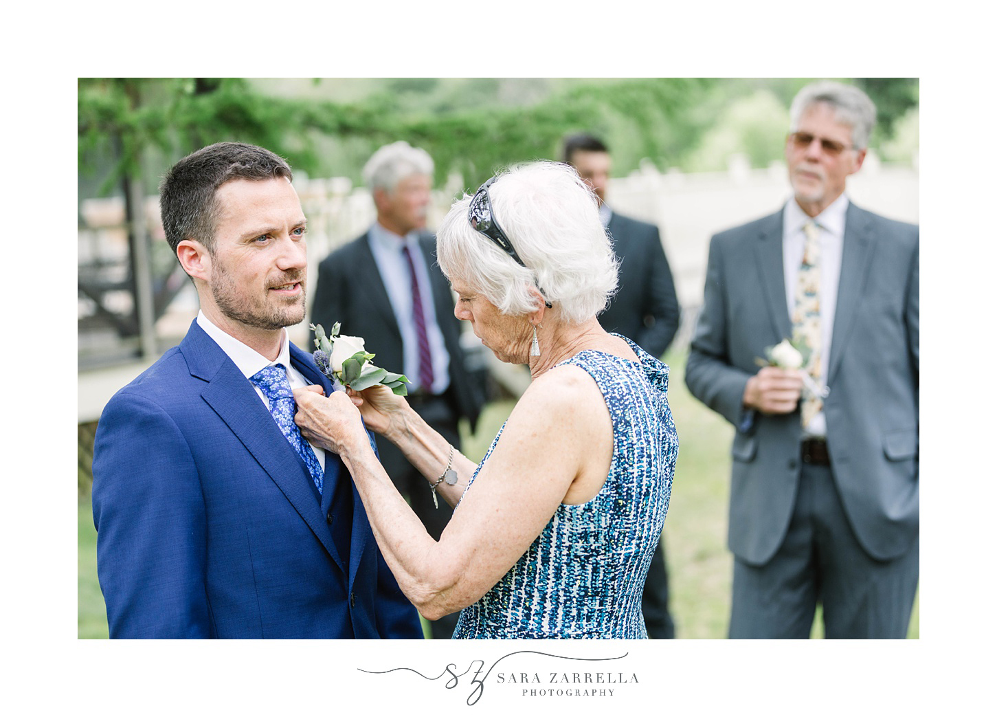 groom's mother helps with boutonniere 