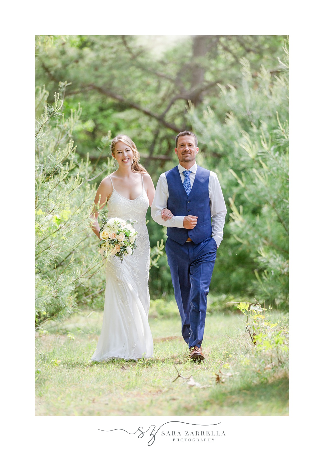 bride and groom walk through woods