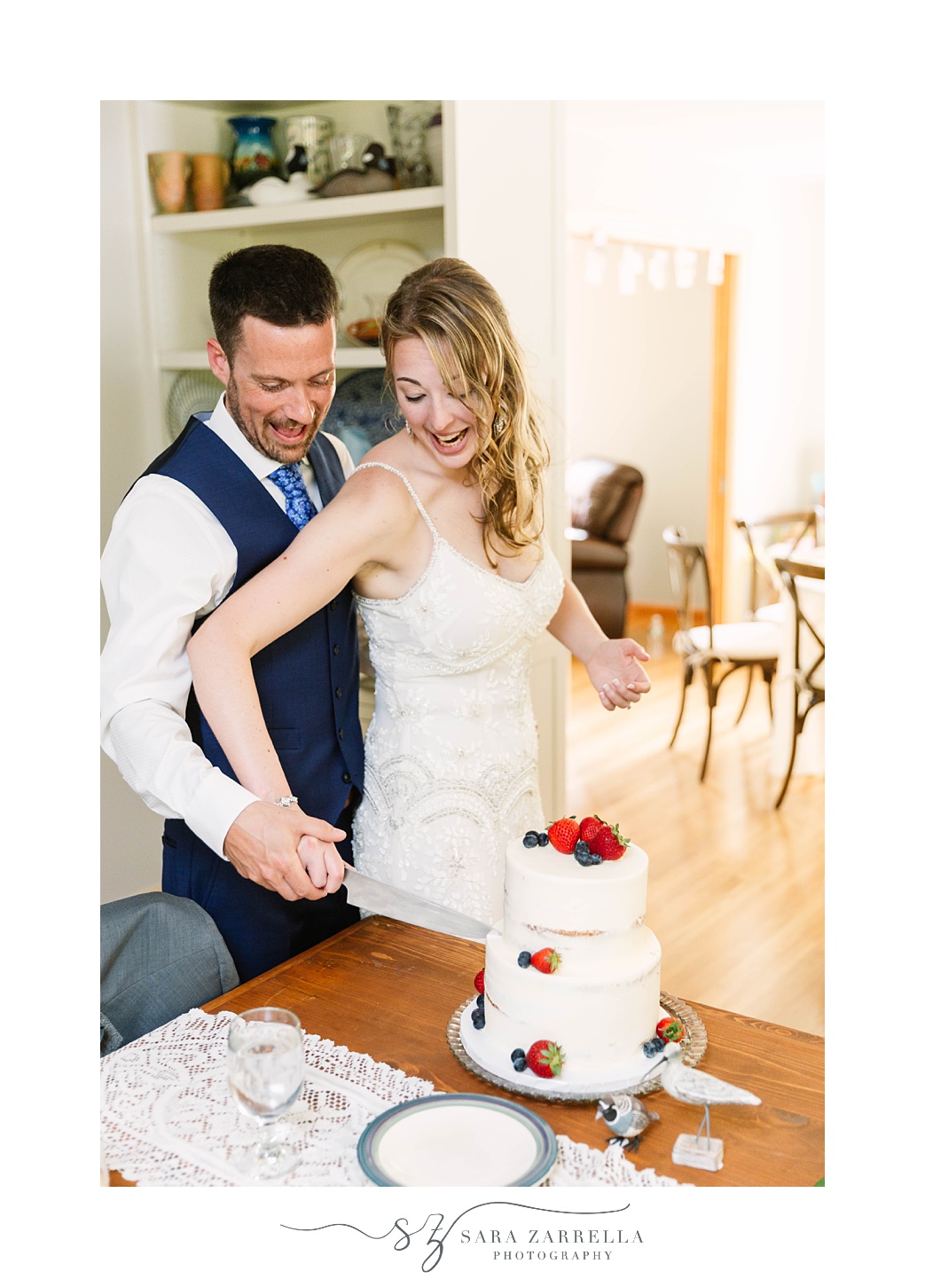 bride and groom cut wedding cake during  intimate backyard wedding reception 