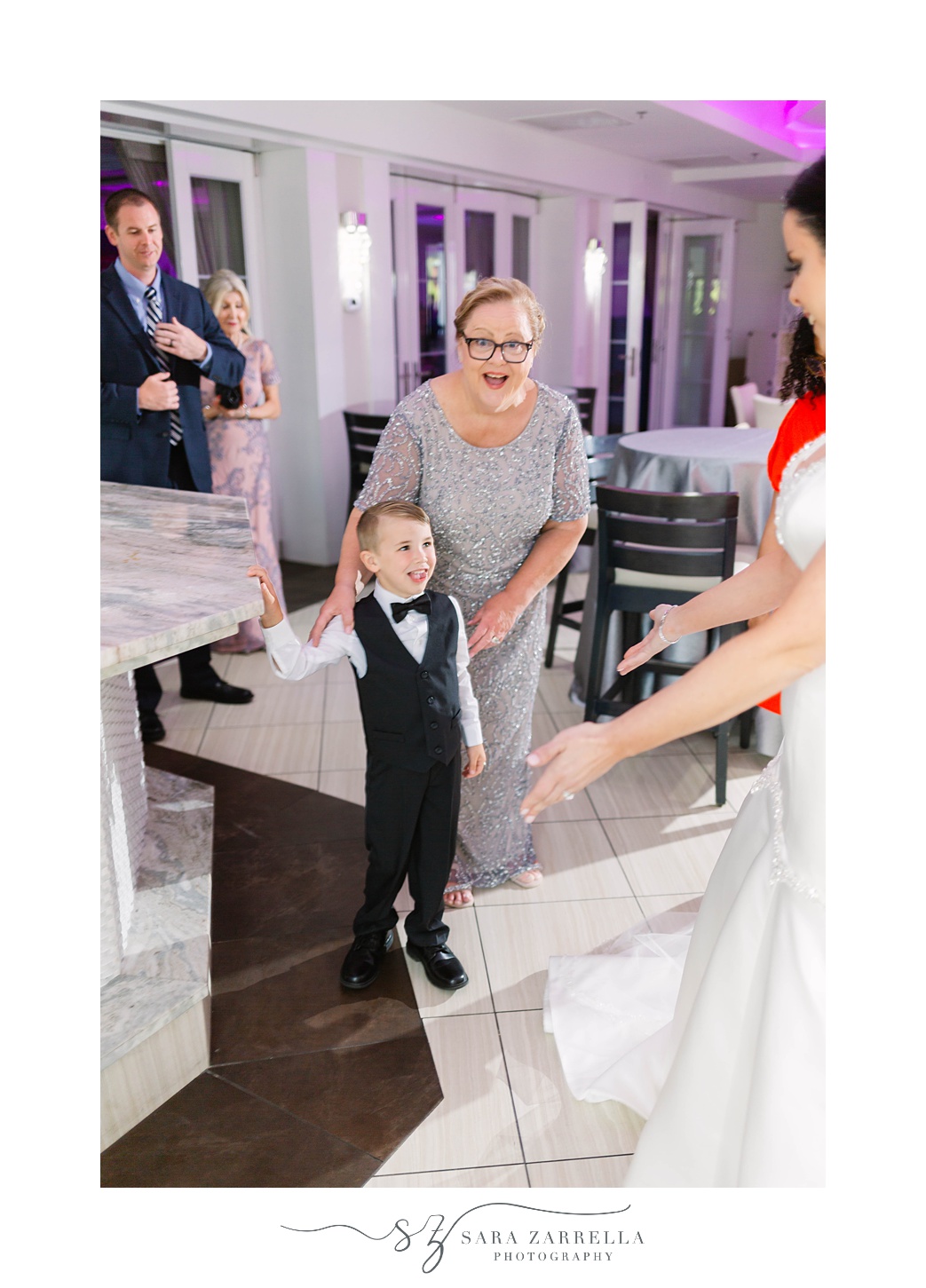 bride smiles at ring bearer while getting ready