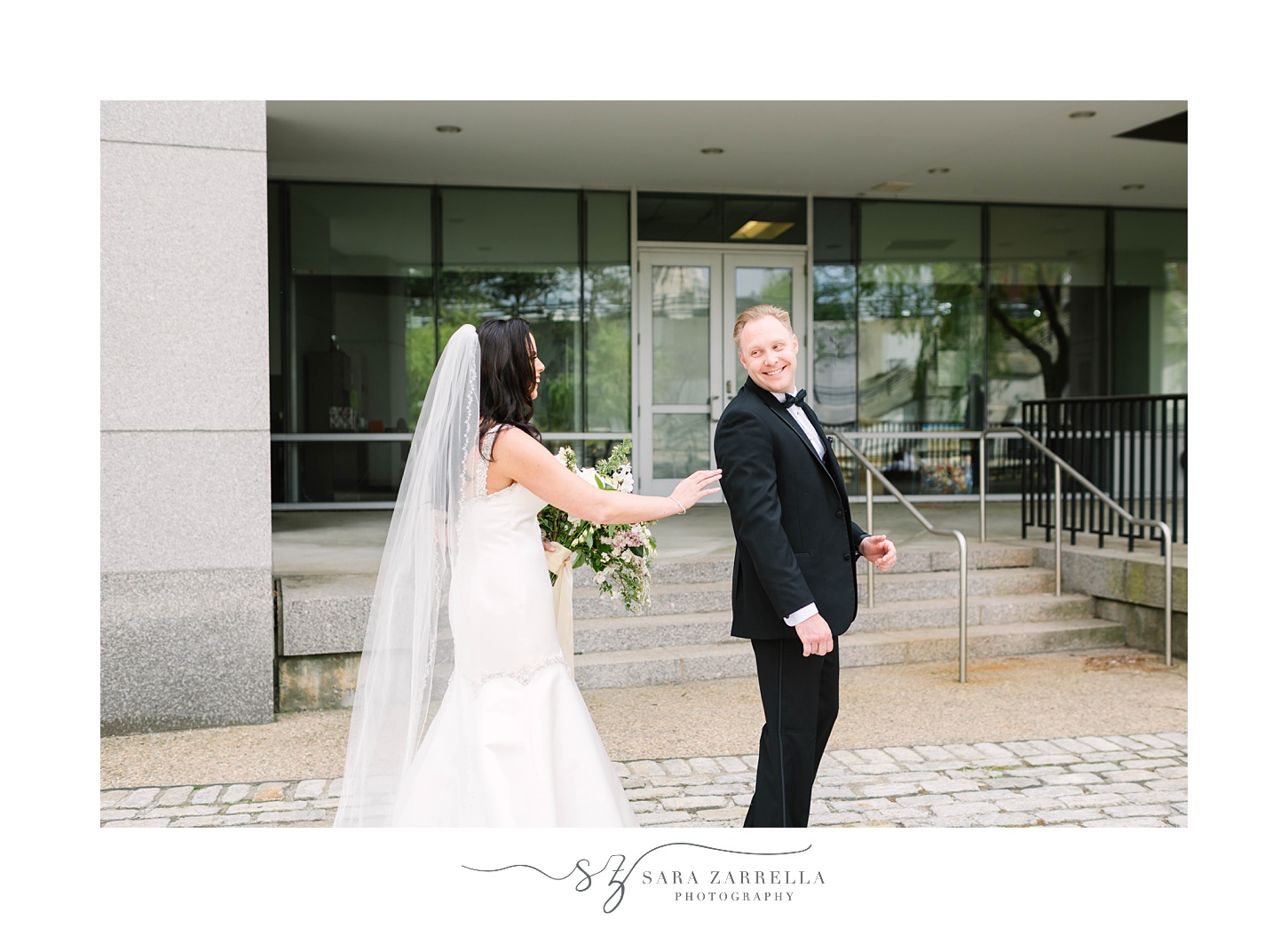 bride taps groom's shoulder during first look outside Skyline at Waterplace