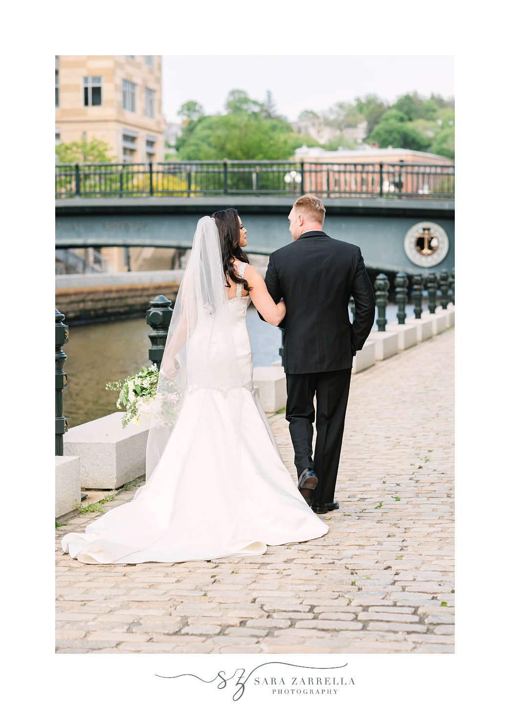 newlyweds walk along water in Providence RI