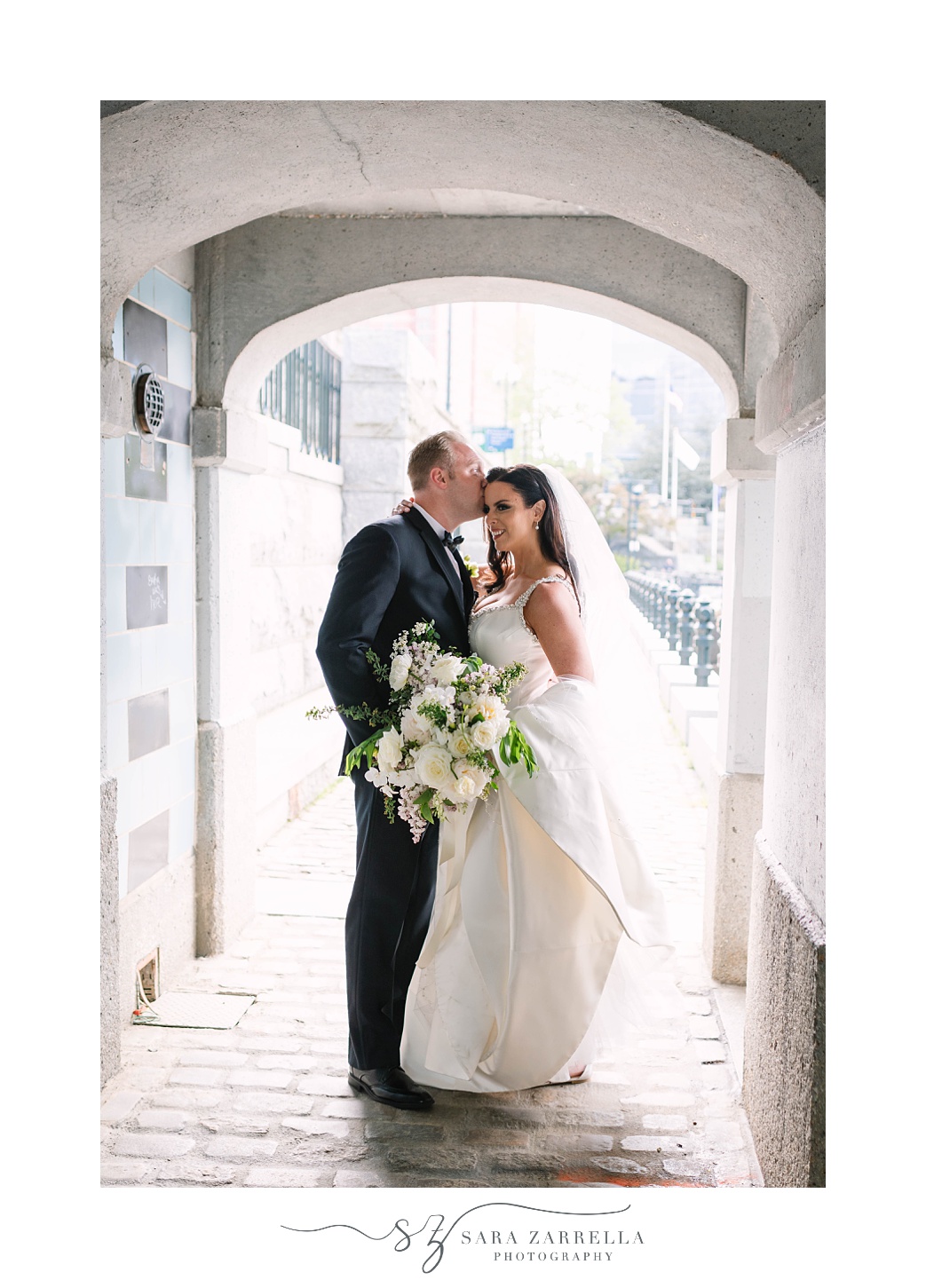 groom kisses bride's forehead under tunnel in Providence RI