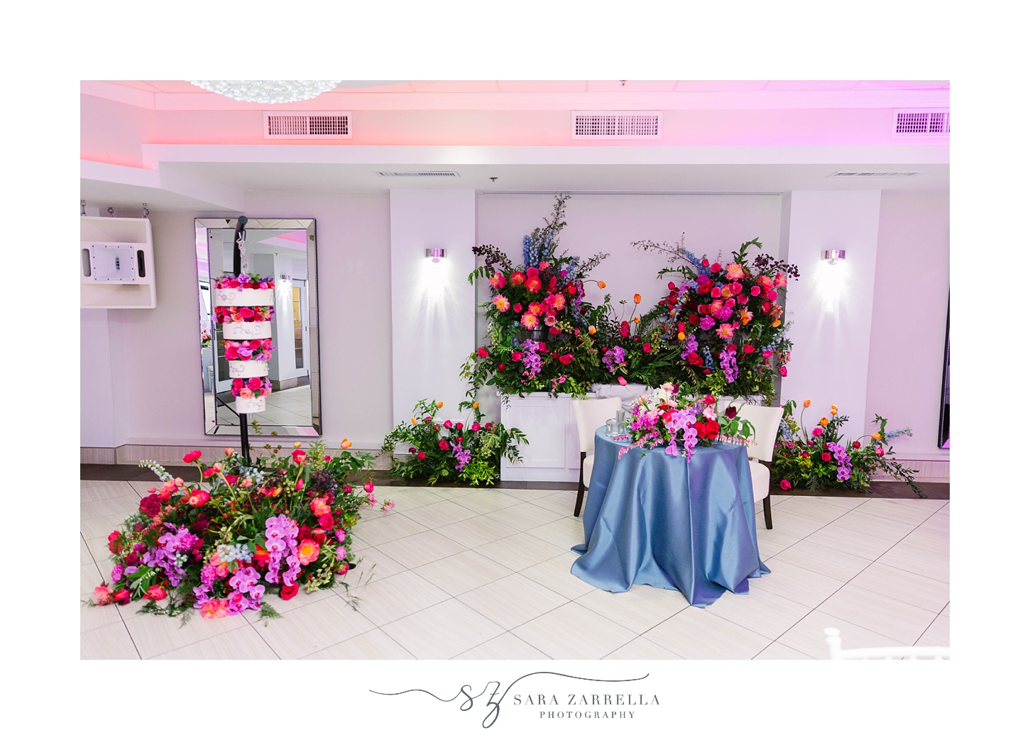sweetheart table with floral wall and hanging cake at Skyline at Waterplace