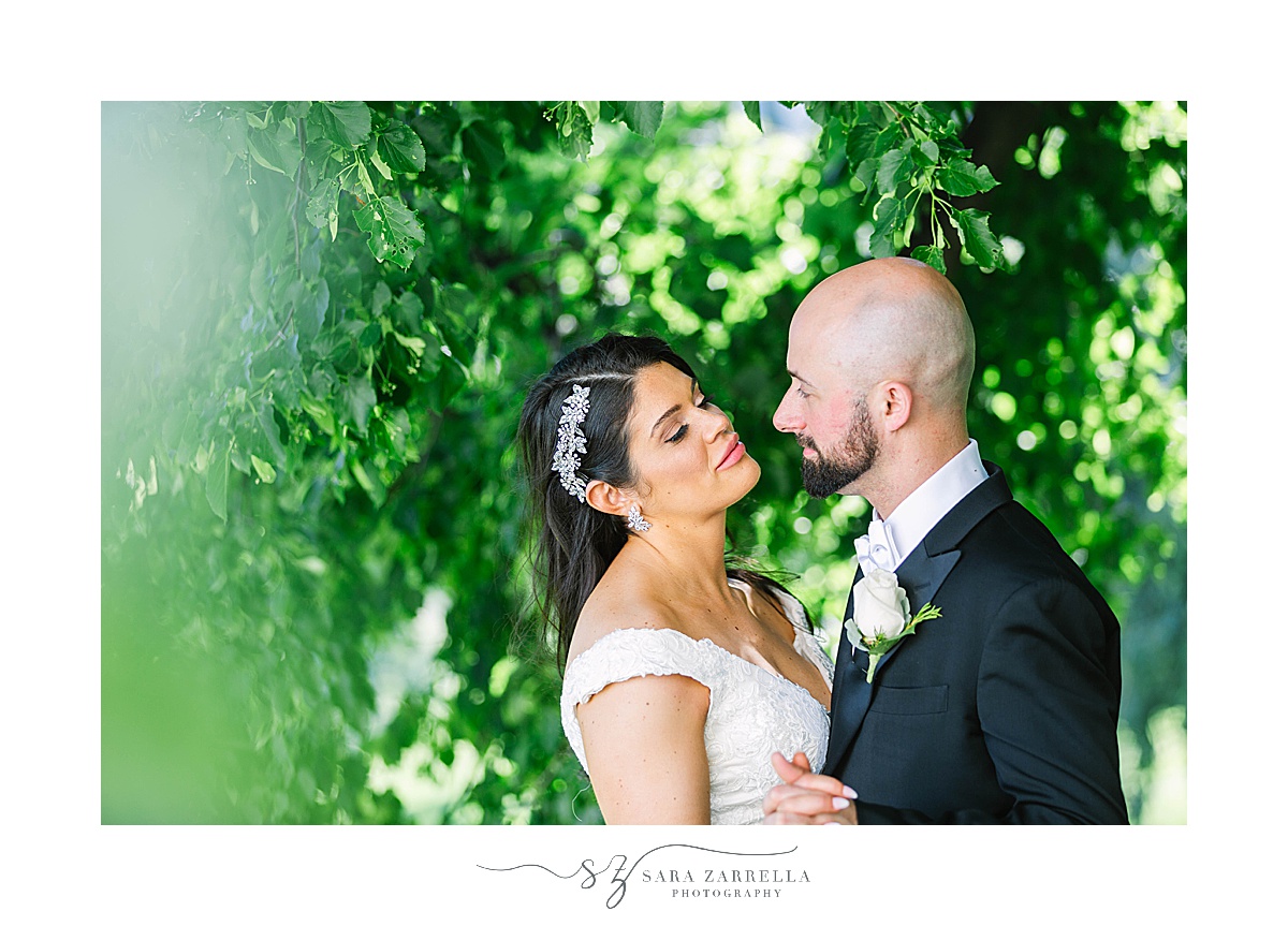 bride and groom dance among green leaves in Cranston, RI