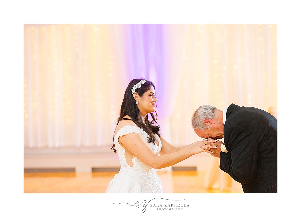dad kisses bride's hands during RI wedding reception