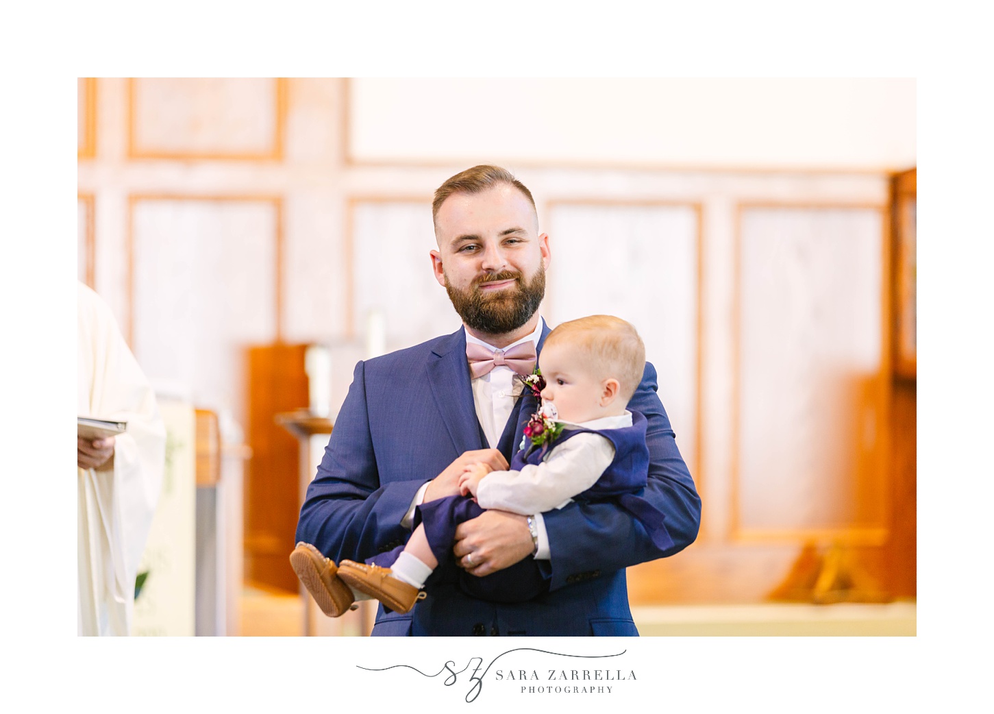 groom hugs toddler son during traditional wedding ceremony in Rochester MA church
