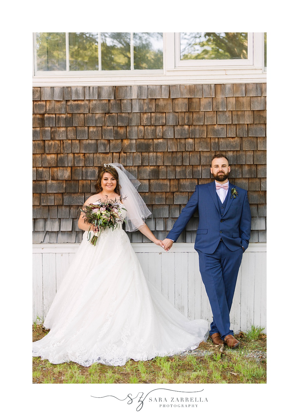 newlyweds hold hands by wooden boards 