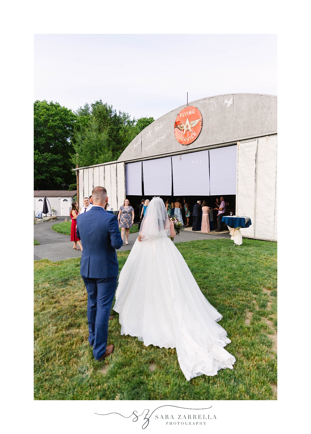 newlyweds walk towards hanger at the Arch at the Meadow