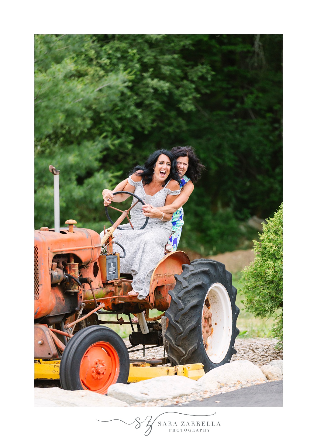 guests have fun on orange tractor during reception at Arch at the Meadow