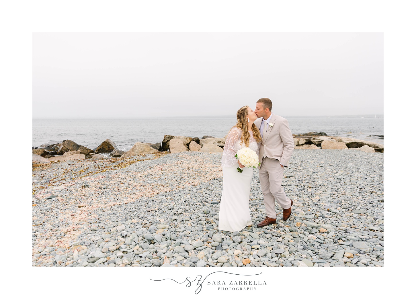 newlyweds kiss on beach at OceanCliff Hotel