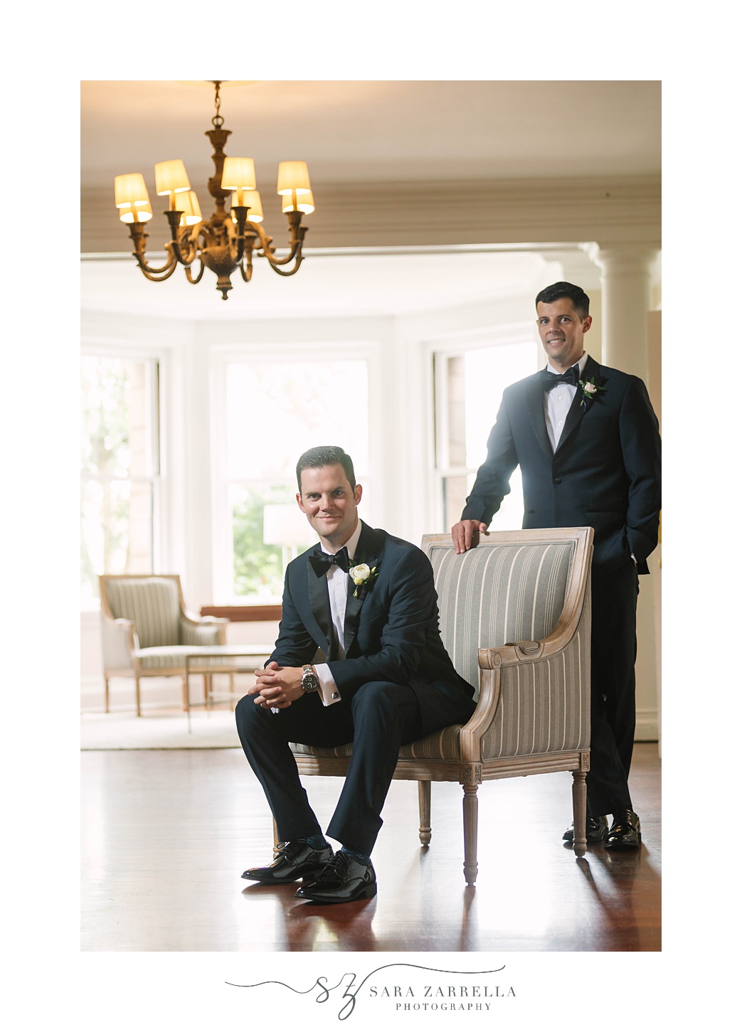 groom sits in chair with brother behind him before RI vow renewal