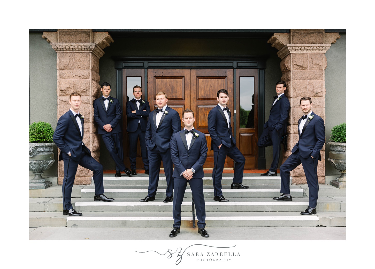 groom and groomsmen pose on steps of OceanCliff Hotel