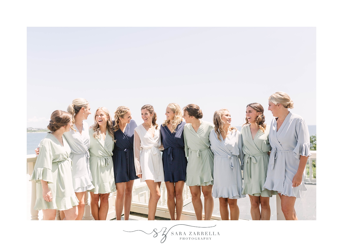 bride and bridesmaids pose in robes on balcony at The Chanler at Cliff Walk