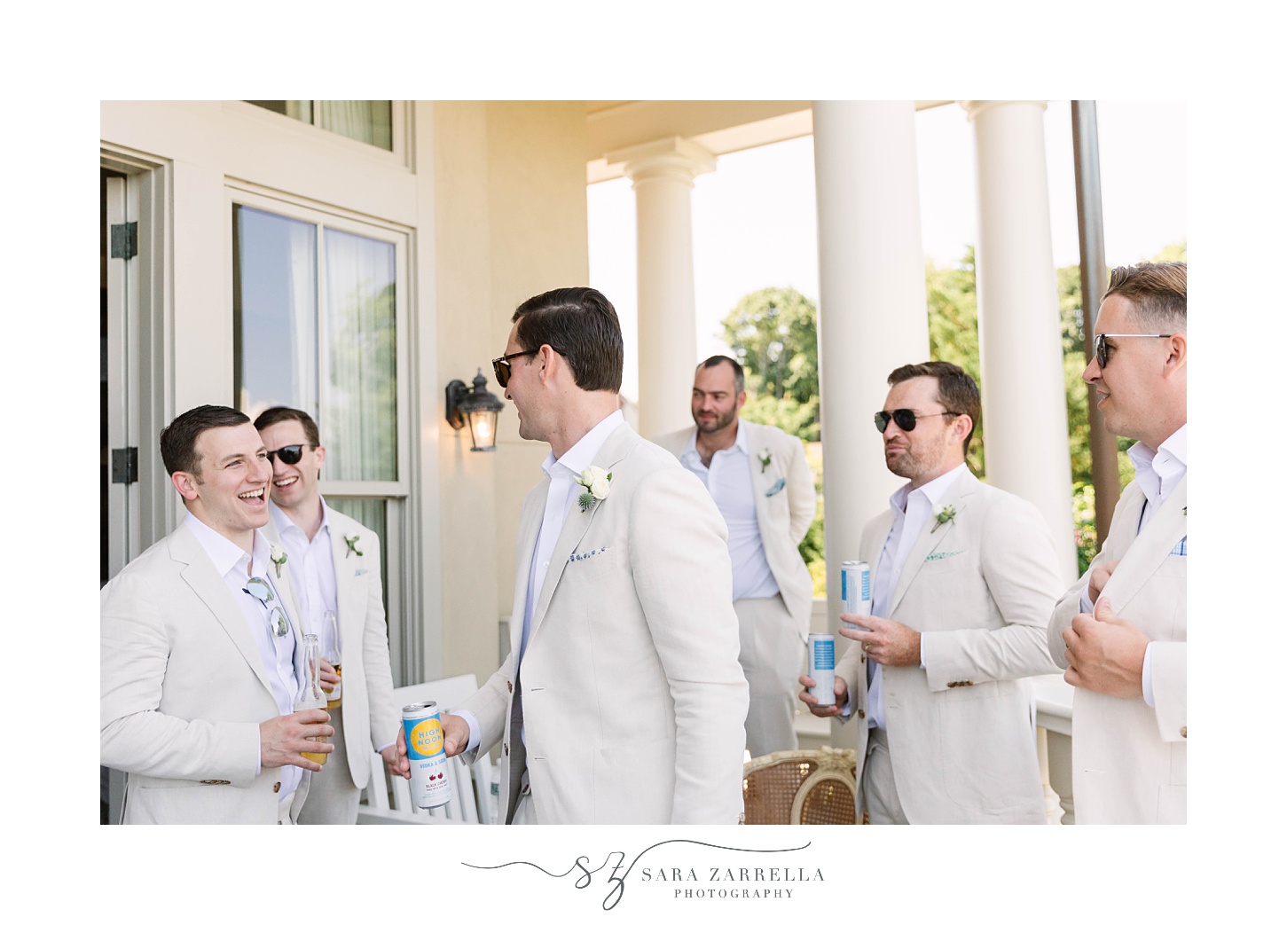 groom and groomsmen share a drink on patio before RI wedding