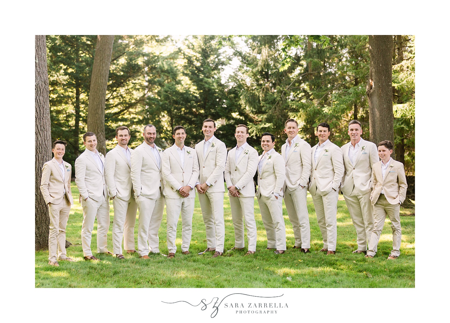 groom poses with groomsmen in tan suits