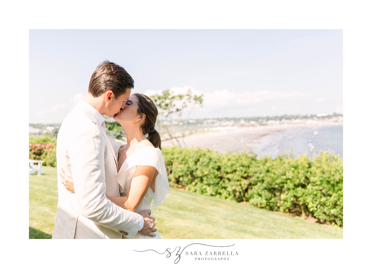 bride and groom kiss by waterfront in Rhode Island 