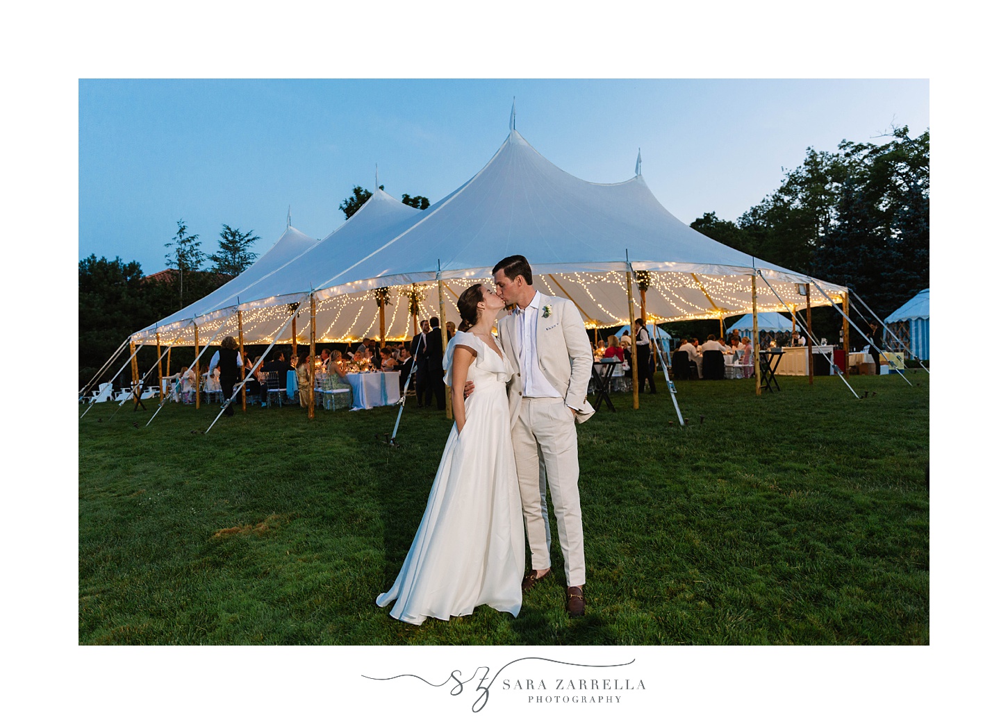 nighttime portrait of bride and groom by tent
