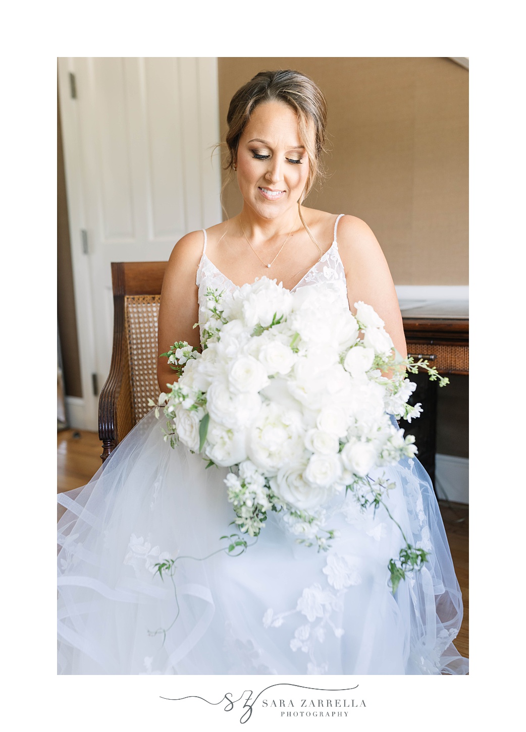 bride sits holding bouquet of flowers