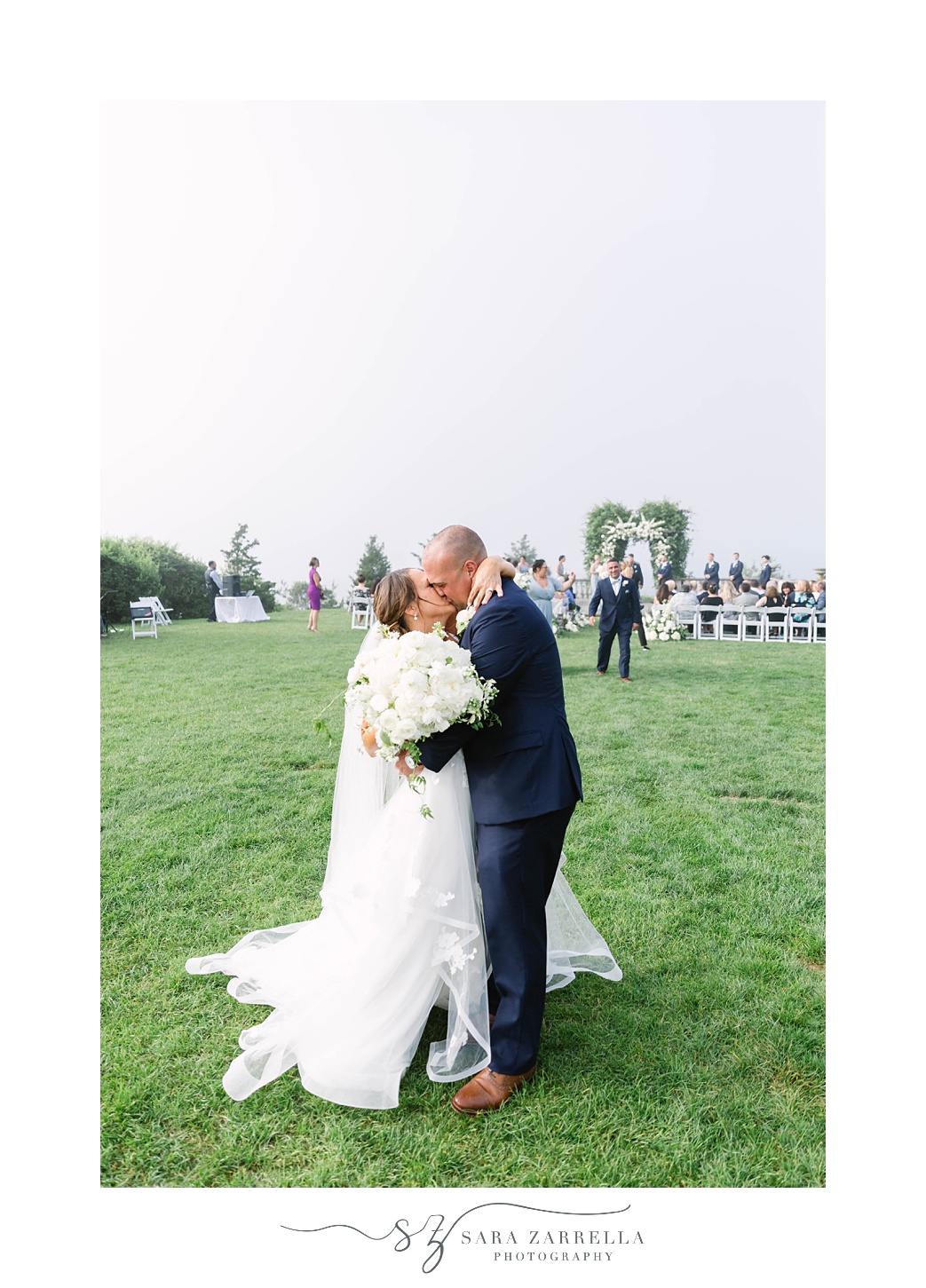 newlyweds kiss after waterfront wedding ceremony in Rhode Island