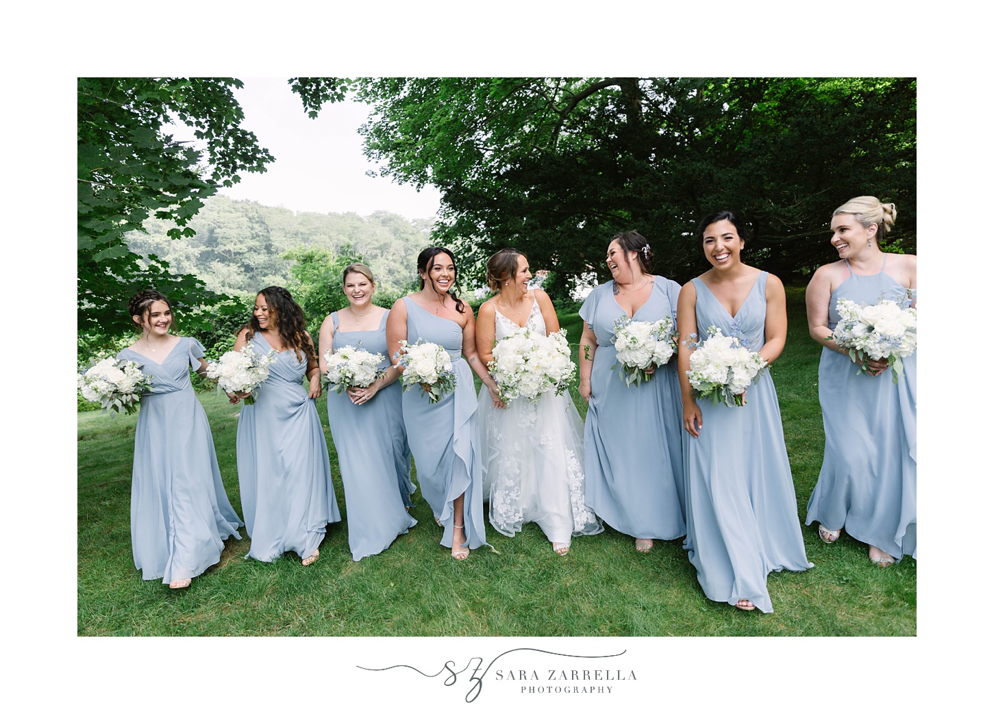 bride and bridesmaids in light blue gowns walk at Castle Hill Inn