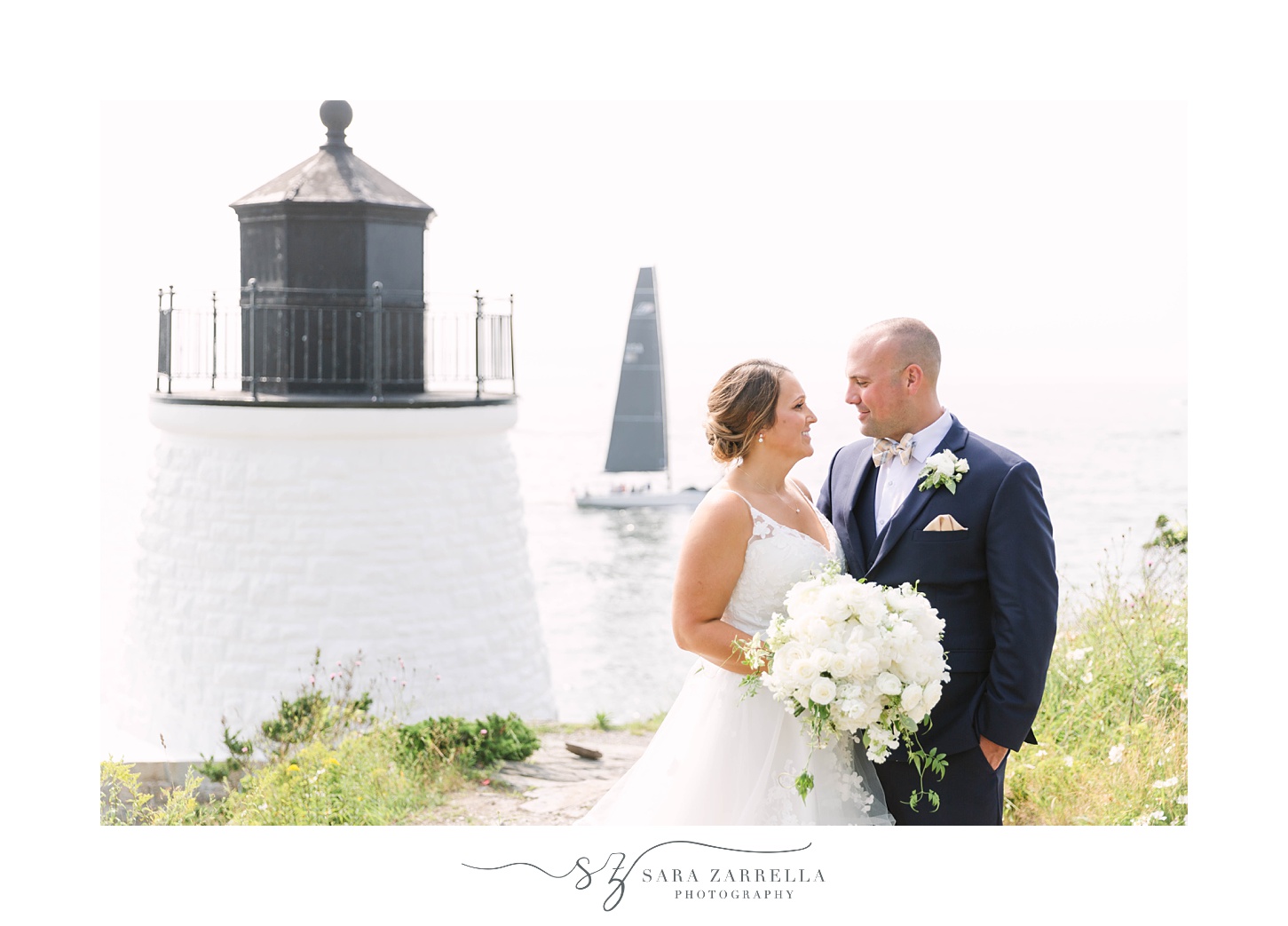 newlyweds pose by white lighthouse in Newport RI