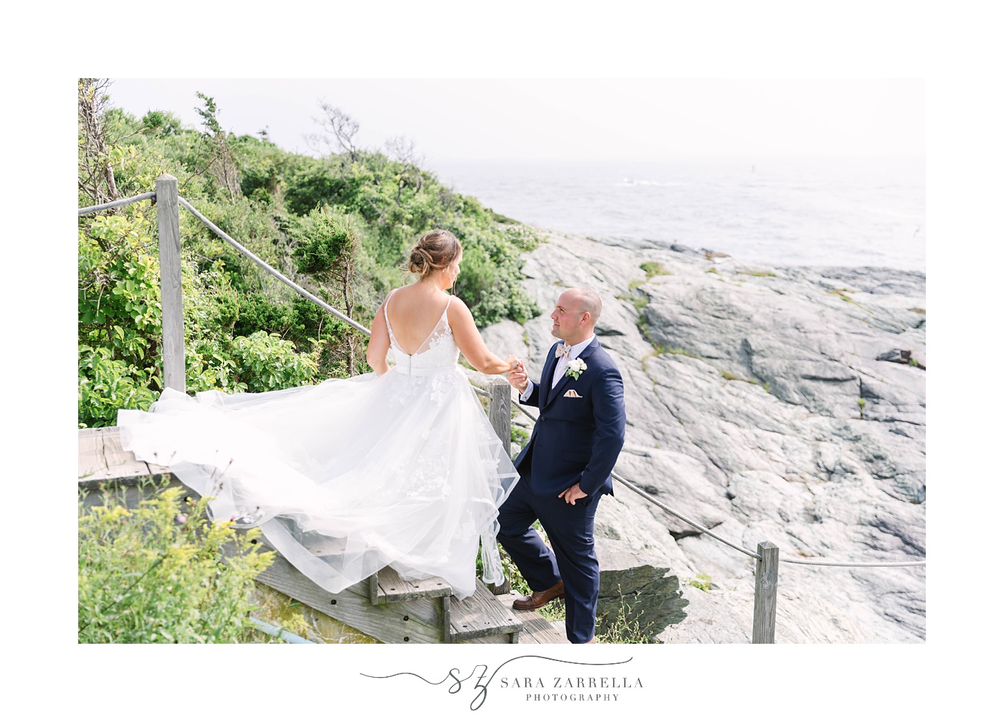 groom helps bride down steps at lighthouse 