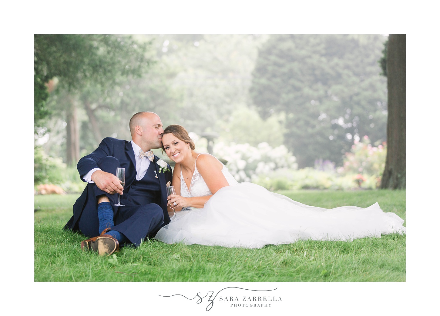 bride leans on groom's arm sitting in grass at Castle Hill Inn