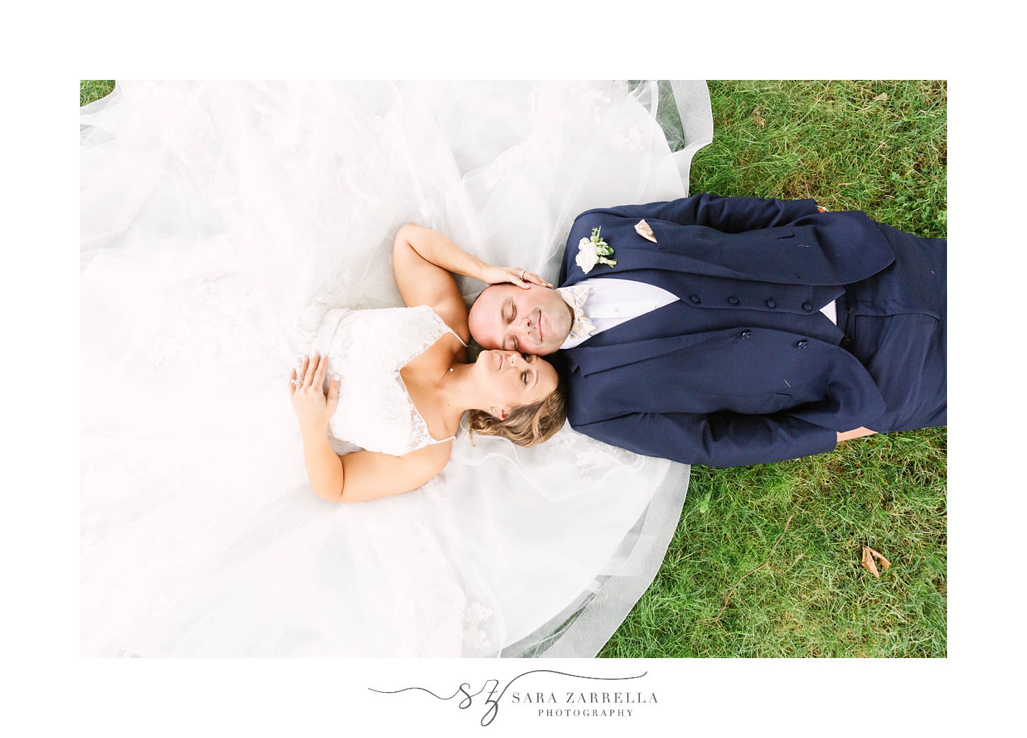 newlyweds lay on grass at Castle Hill Inn
