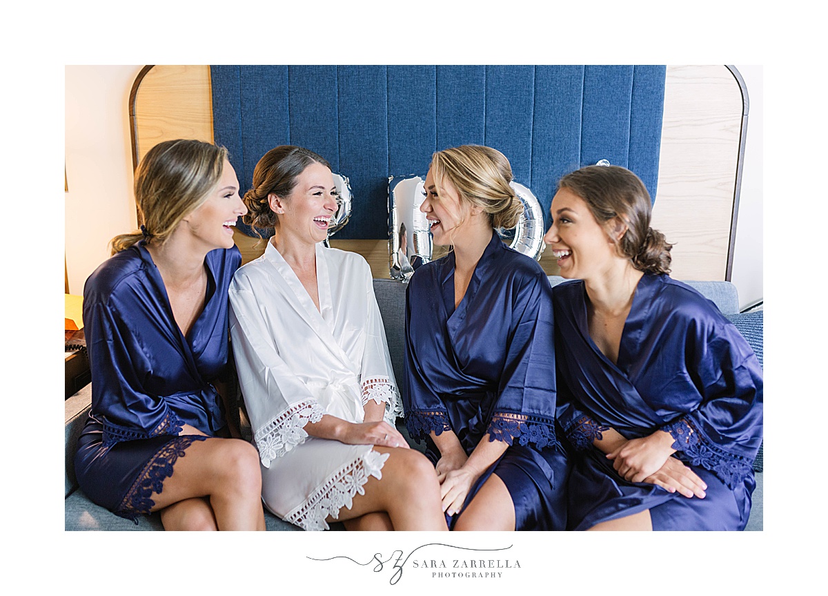 bride laughs with bridesmaids in blue robes 