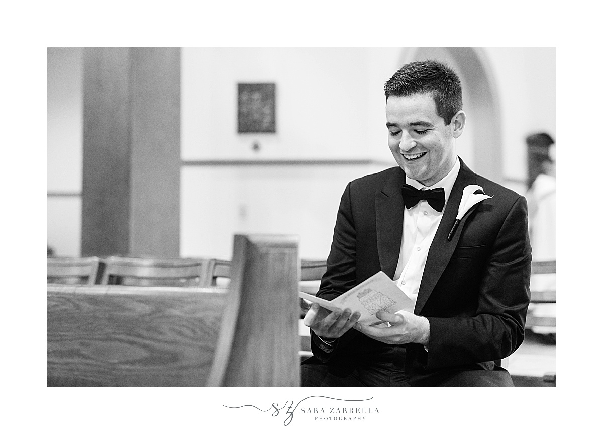 groom reads card on wedding day at Providence College