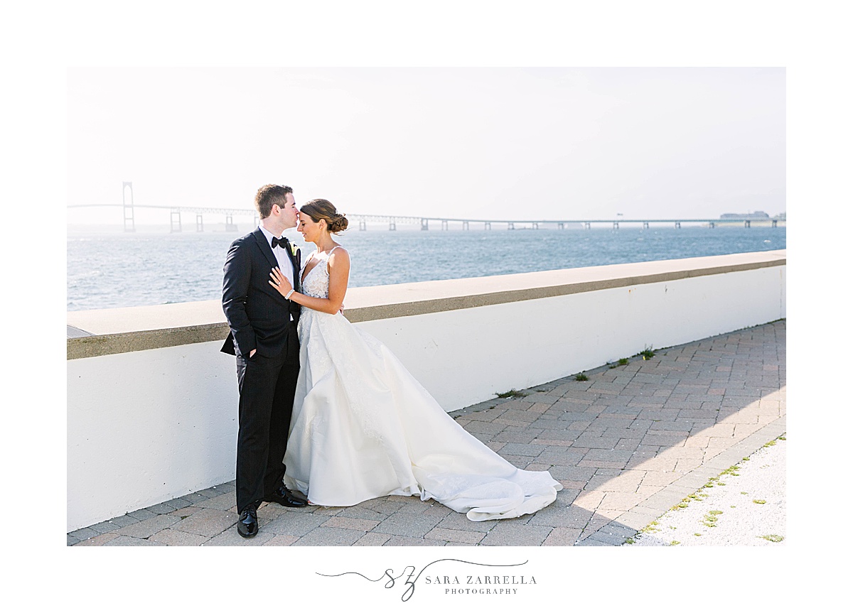 bride and groom hug on bridge in Newport RI