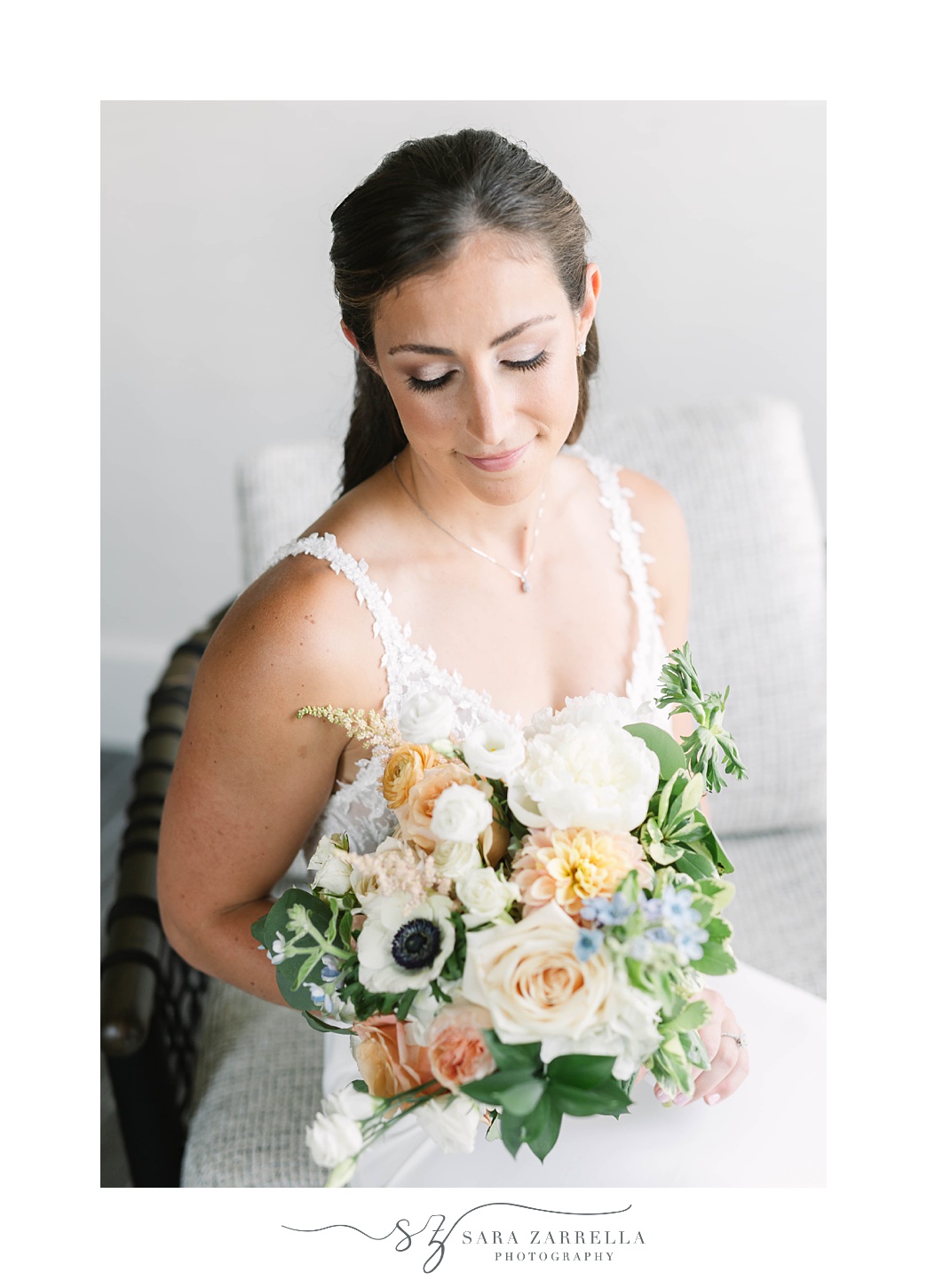 bride looks down at bouquet of flowers before Gurney’s Newport Resort wedding day