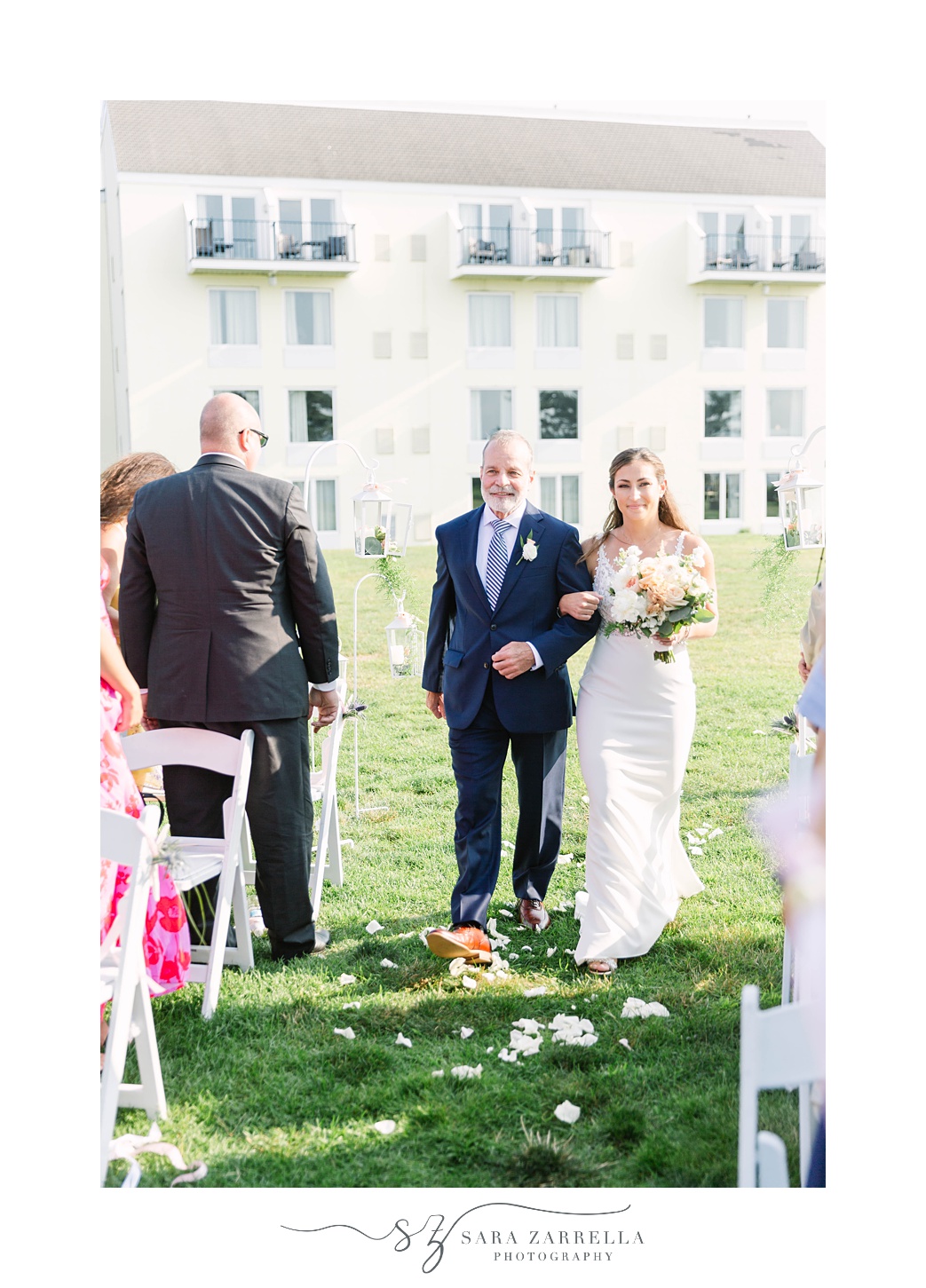 bride walks down aisle with dad during Gurney’s Newport Resort wedding day
