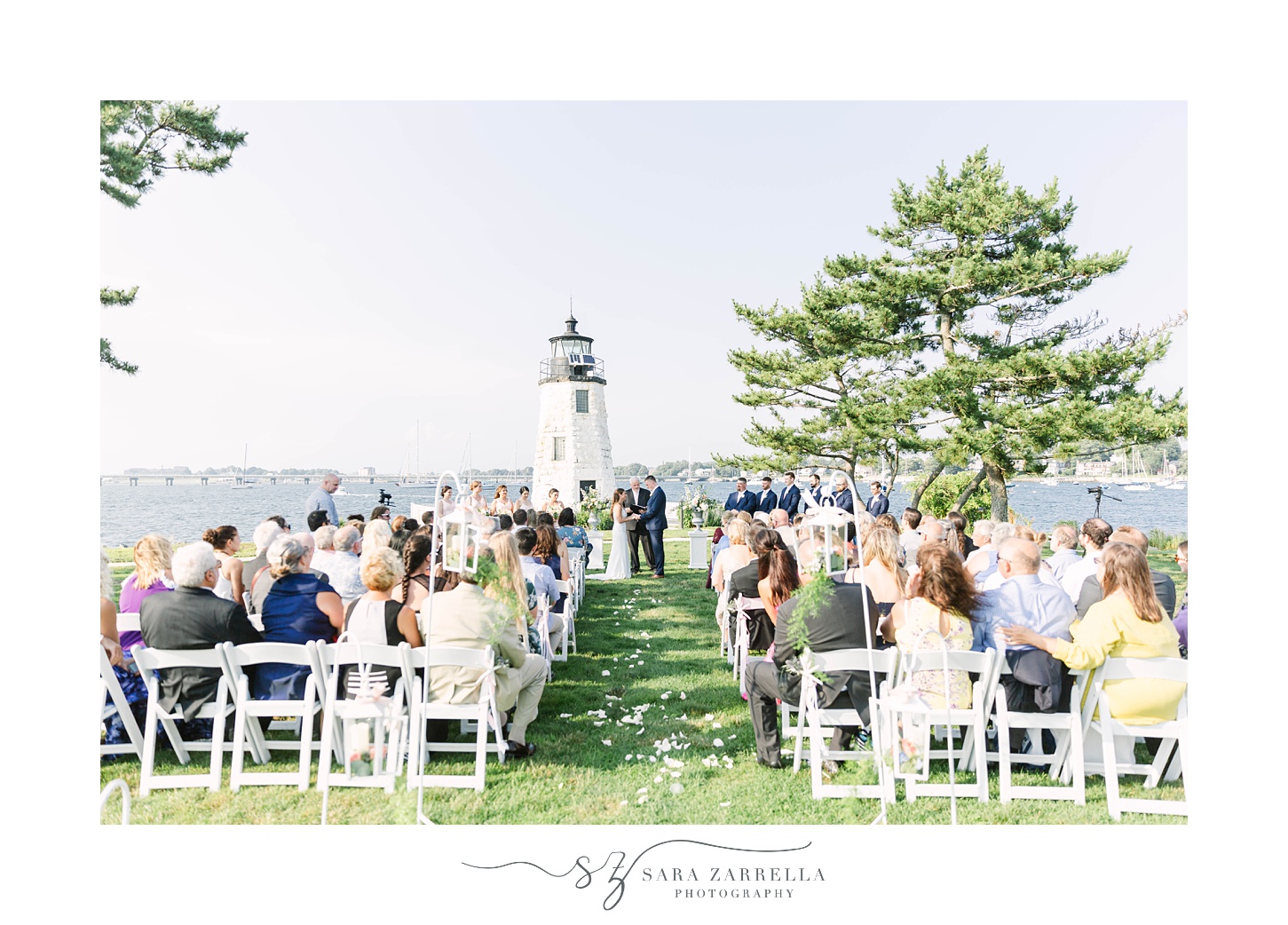 wedding ceremony by white lighthouse at Gurney's Newport Resort