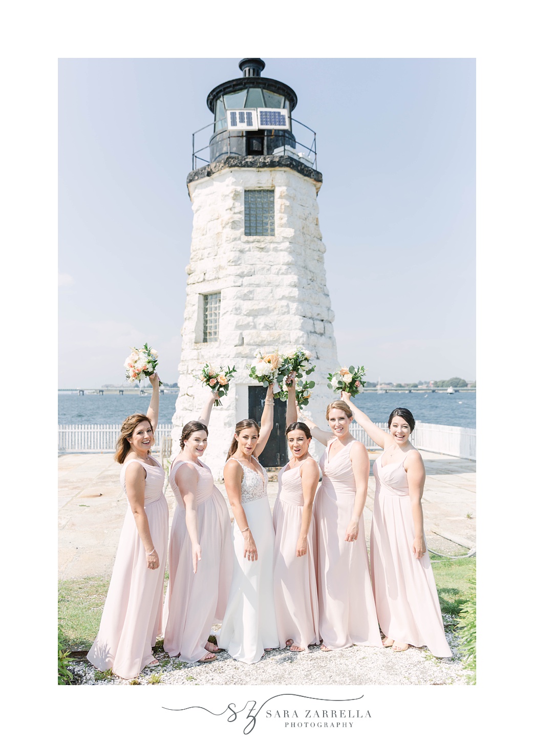 bridesmaids lift bouquets by lighthouse on Gurney’s Newport Resort wedding day