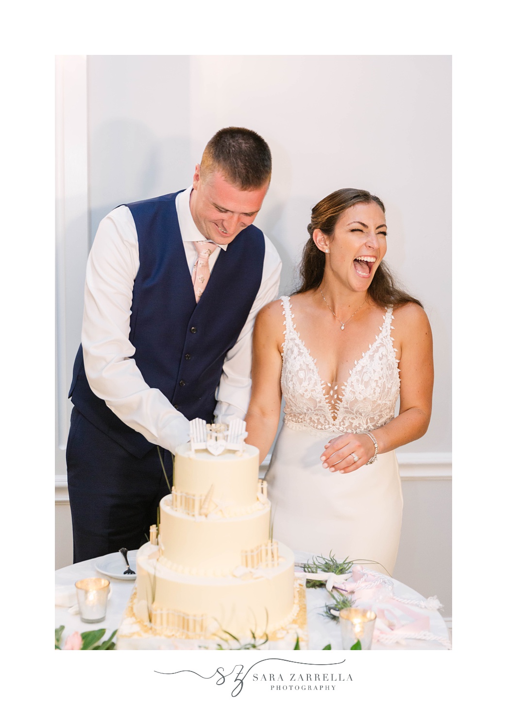 bride and groom laugh cutting wedding cake