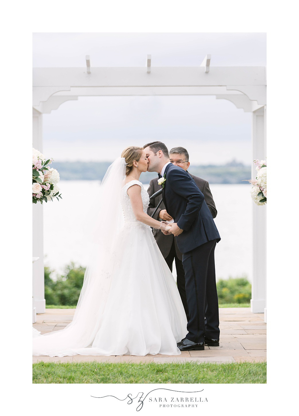 groom kisses bride during waterfront ceremony for vow renewal at OceanCliff Hotel