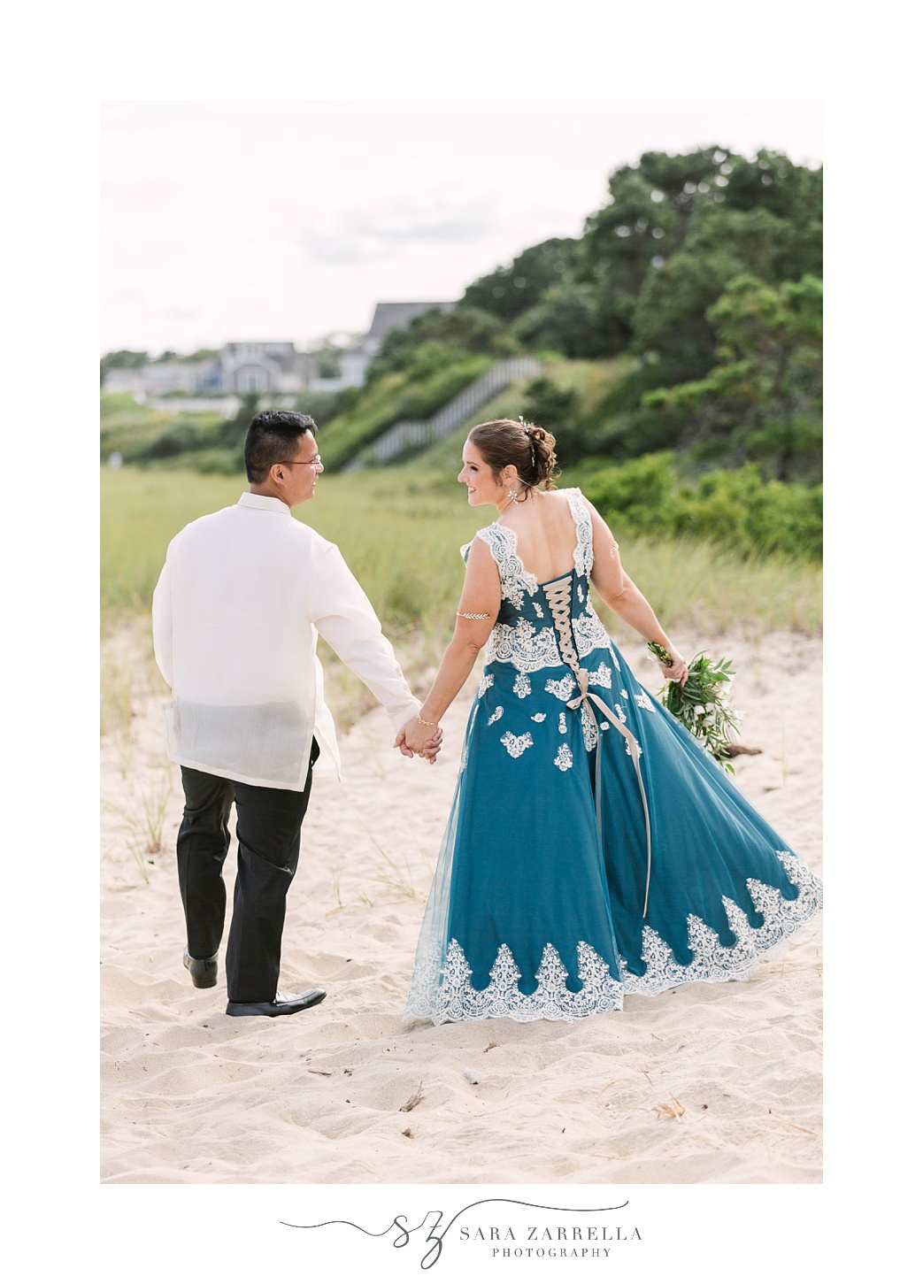 bride and groom hold hands walking through sand at Popponesset Inn