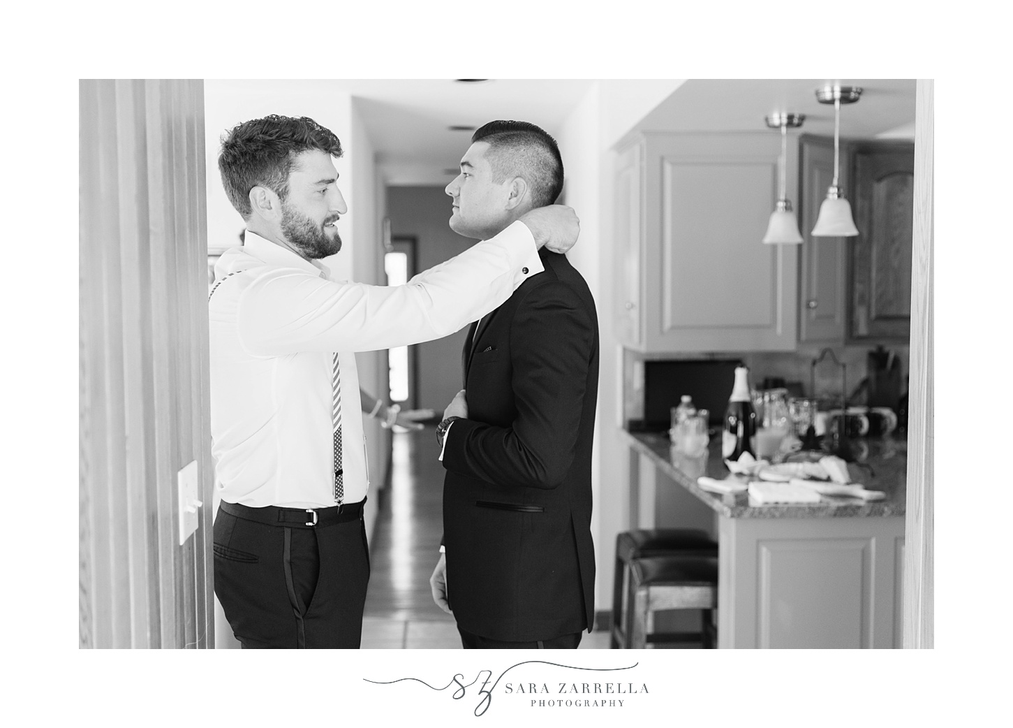groomsman adjusts tie for groom before MA wedding 